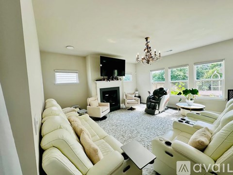 A living room with a white couch and a chandelier.