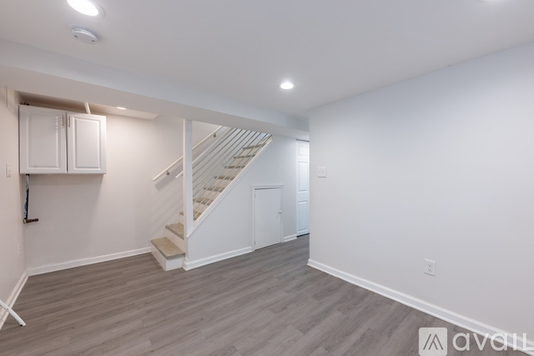 A spacious room with a staircase and a cabinet.
