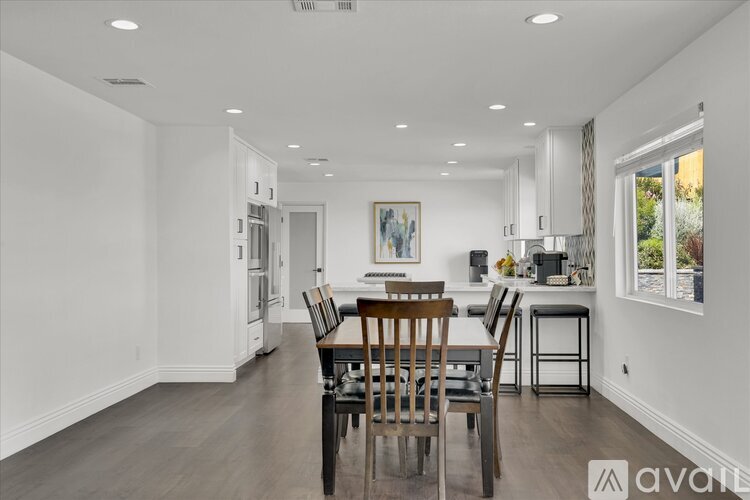 A dining room with a wooden table and chairs.