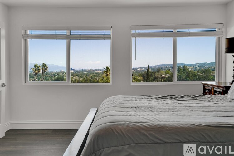 A bedroom with a large bed and a view of the mountains.
