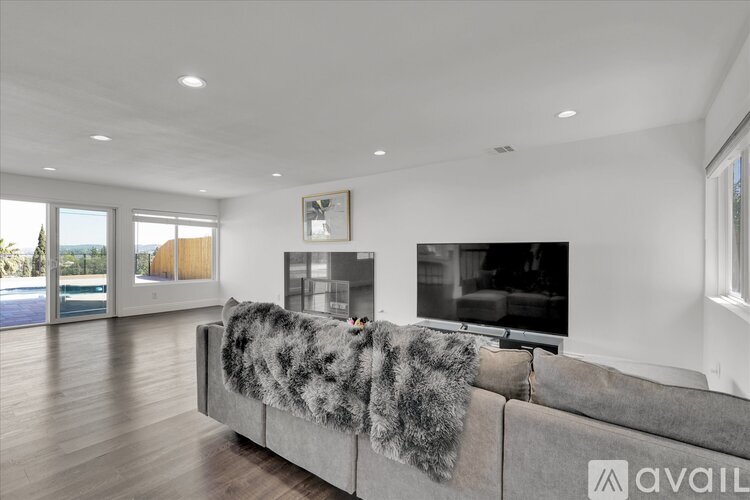 A modern living room with a grey couch and a flat screen TV.