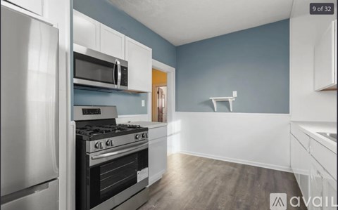 A kitchen with a stainless steel refrigerator, microwave, and stove.