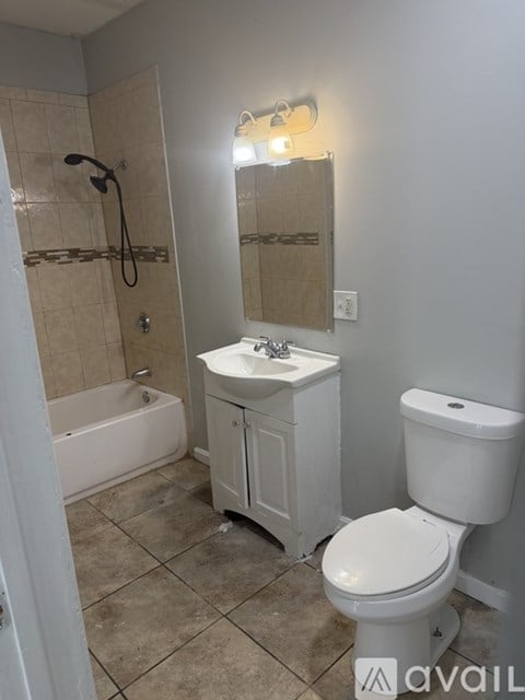 A bathroom with a toilet, sink, and bathtub.