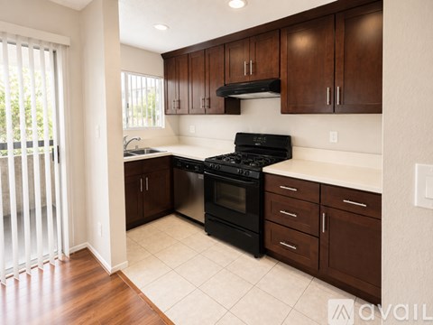 A kitchen with dark brown cabinets and a black stove top oven.