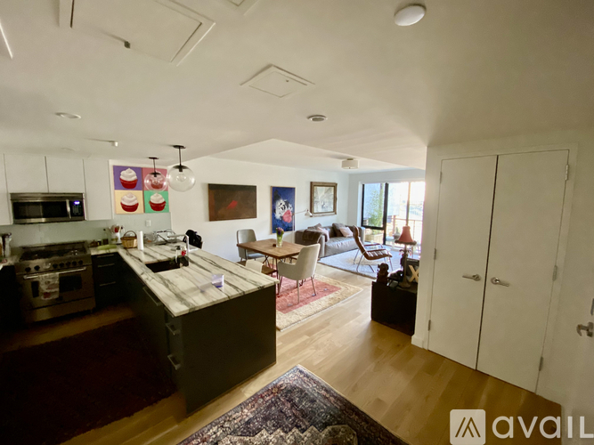 A kitchen with a wooden island and a dining area with chairs.