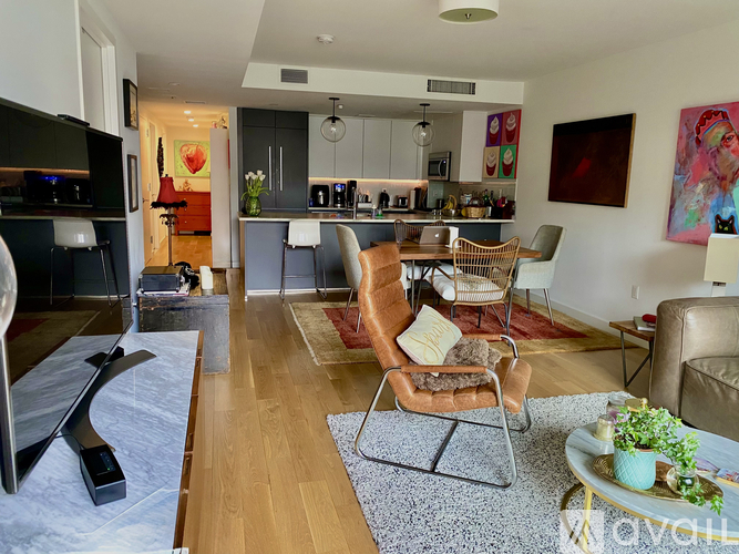 A living room with a TV, a couch, a chair, and a coffee table.