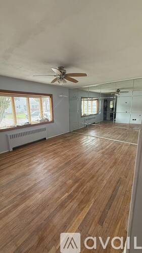 A room with wooden floors and a ceiling fan.