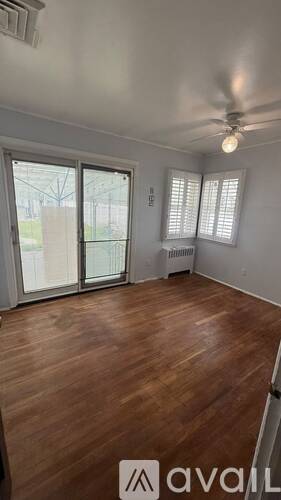 A room with wooden flooring and a ceiling fan.
