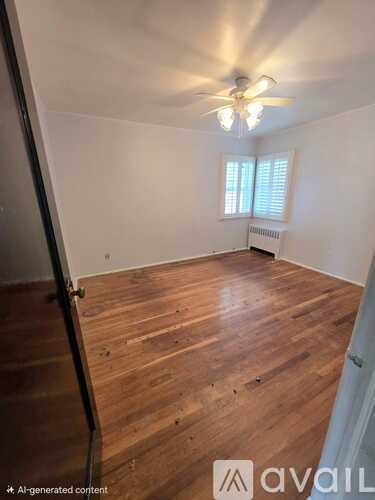 A room with wooden flooring and a ceiling fan.