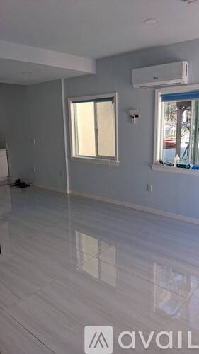 A room with a large window and a white floor.