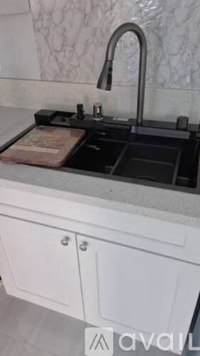 A kitchen sink with a faucet and a drainer underneath it.