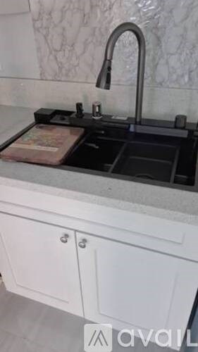 A kitchen sink with a faucet and a drainer underneath it.