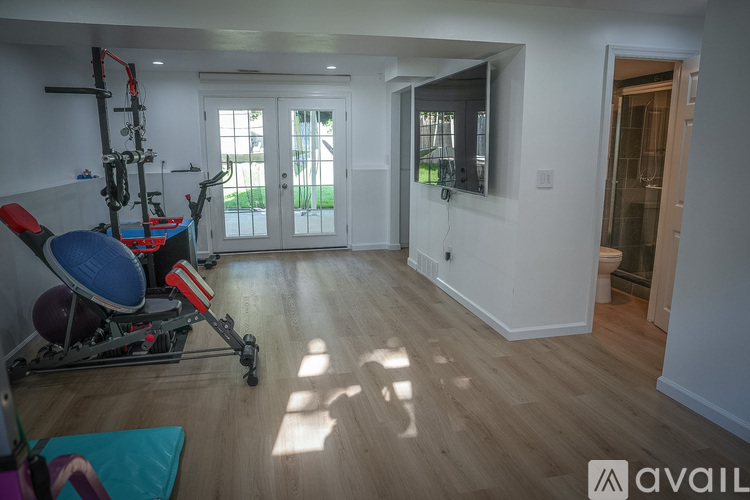 A gym room with a pilates reformer and a yoga mat.
