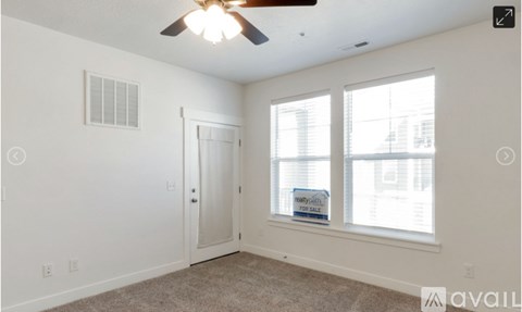 A room with a ceiling fan and a window with blinds.