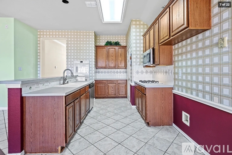 A kitchen with wooden cabinets and a tiled floor.