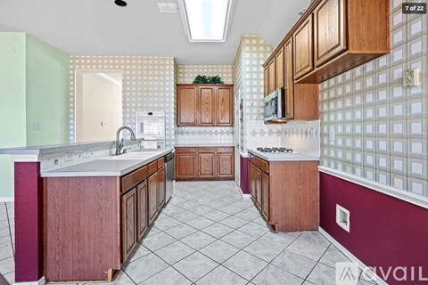 A kitchen with wooden cabinets and a tiled floor.