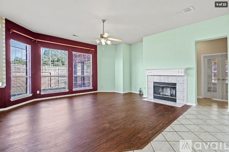 A living room with a fireplace and a ceiling fan.