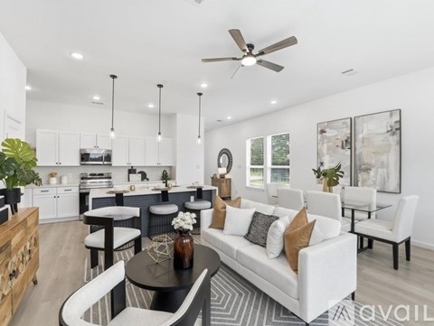 A modern kitchen and living room with a dining table and chairs.