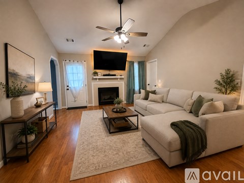 A living room with a white couch and a fireplace.