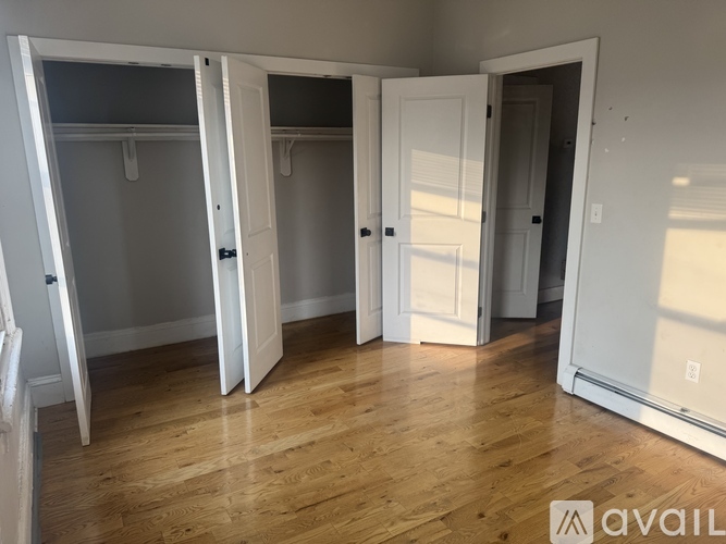 A room with white doors and wooden floors.