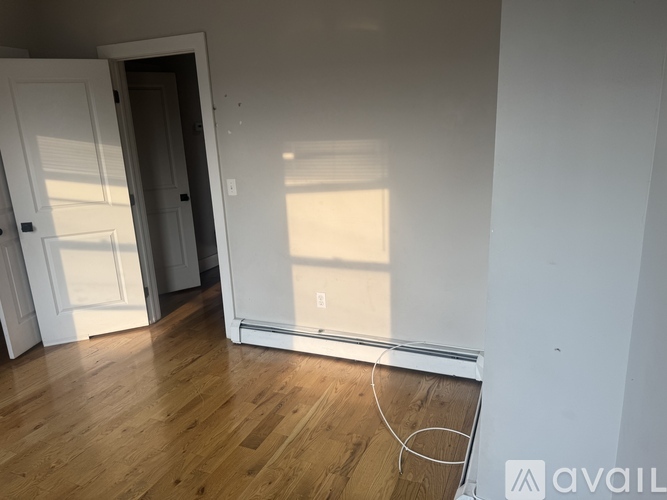 A room with a wooden floor and a white door.