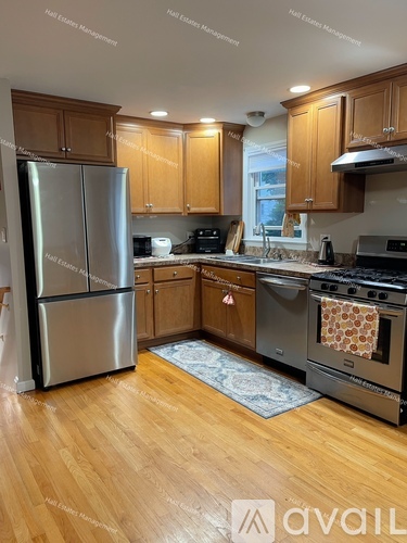 A kitchen with wooden cabinets and a stainless steel refrigerator.