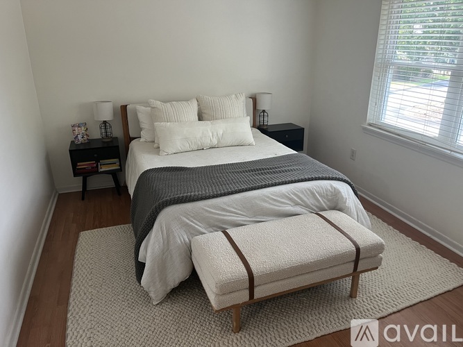 A bedroom with a large bed and a bench in front of it.