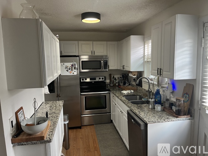 A kitchen with white cabinets and stainless steel appliances.