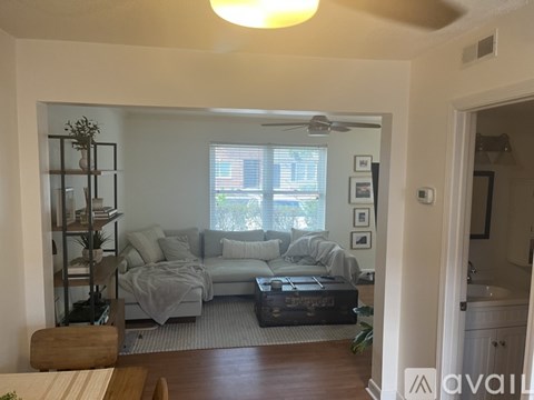 A living room with a grey couch and a wooden table.
