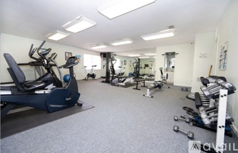 A spacious gym with a variety of equipment including treadmills, weights, and exercise machines.