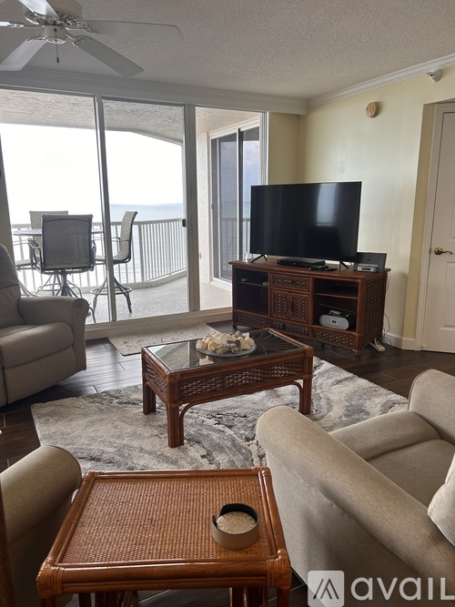 A living room with a television and sliding glass doors.