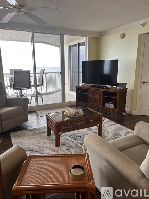 A living room with a television and sliding glass doors.