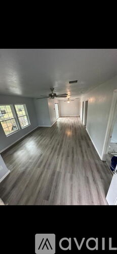 A room with wooden flooring and a ceiling fan.