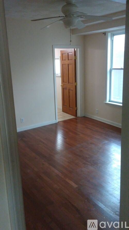 A room with wooden floors and a ceiling fan.