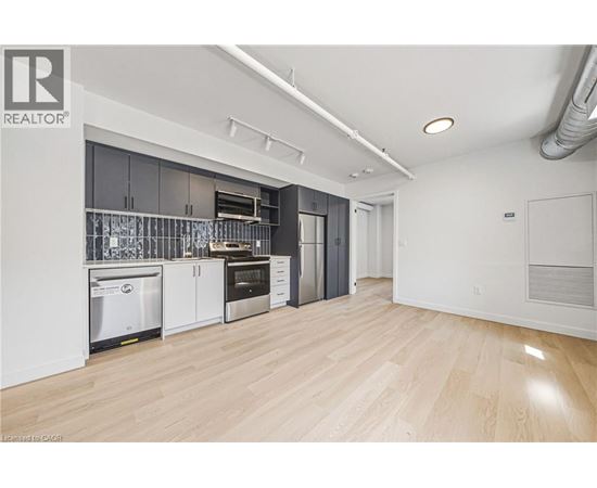 A kitchen with white cabinets and a wooden floor.