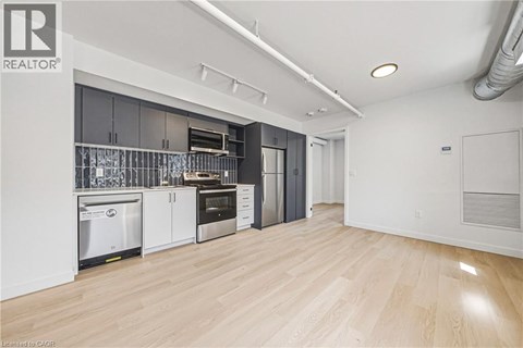 A kitchen with white cabinets and a wooden floor.