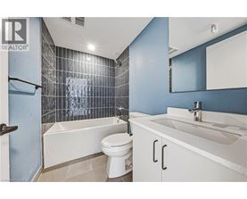 A white toilet sits in a bathroom with blue walls and a white sink.