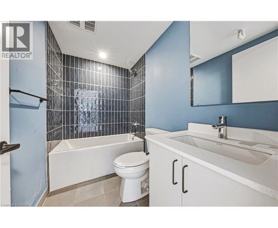 A white toilet sits in a bathroom with blue walls and a white sink.