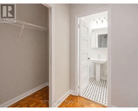 A bathroom with a toilet, sink and mirror.