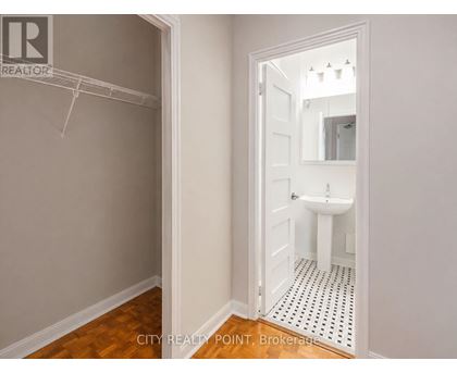 A bathroom with a toilet, sink and mirror.