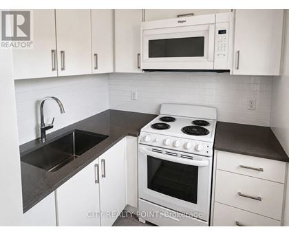 A white stove and microwave in a kitchen with white cabinets.