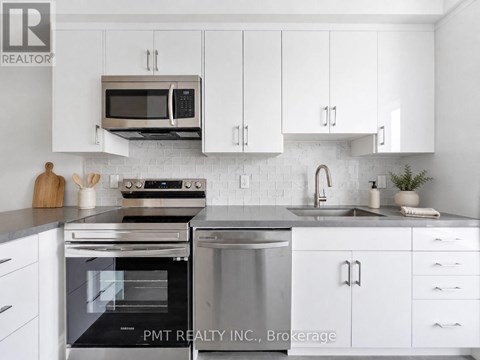 A modern kitchen with white cabinets and stainless steel appliances.