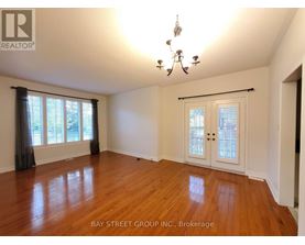 A room with wooden floors and a chandelier.