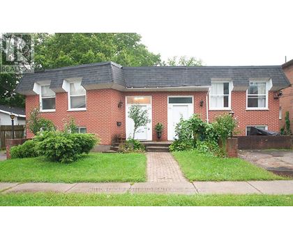 A red brick house with a white door and windows.