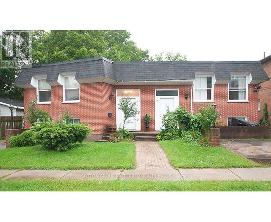 A red brick house with a white door and windows.