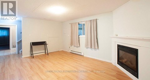 A room with a fireplace and a laptop on a table.