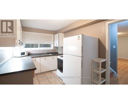 A kitchen with a refrigerator, microwave, and oven.