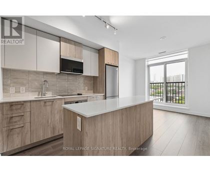A modern kitchen with wooden cabinets and a large island.