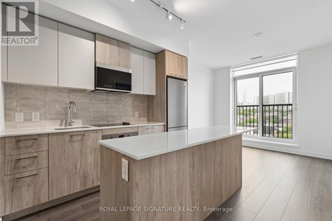A modern kitchen with wooden cabinets and a large island.