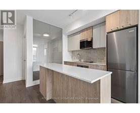 A modern kitchen with a white countertop and stainless steel appliances.